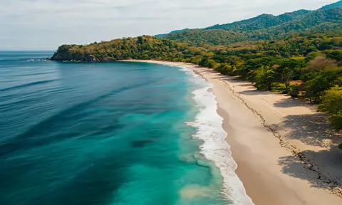 Camera moves along a tropical beach as the waves roll in, looks like paradise